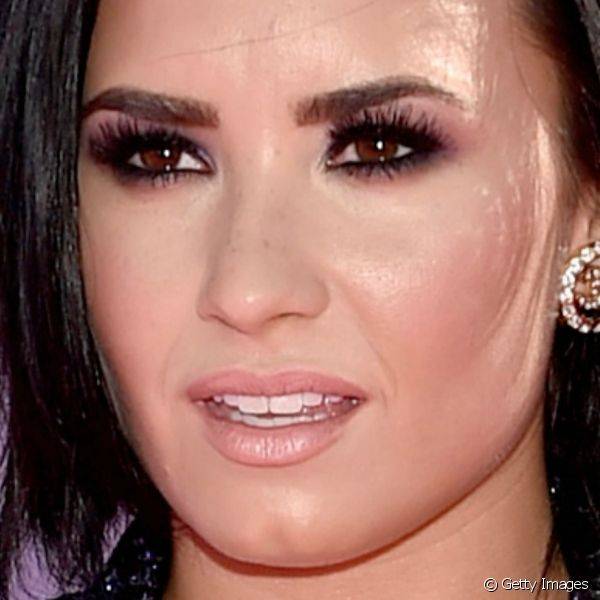 Demi Lovato combinou cílios postiços e sobrancelhas desenhadas com sombra vinho bem suave e, nas unhas, ela usou um esmalte azul metalizado